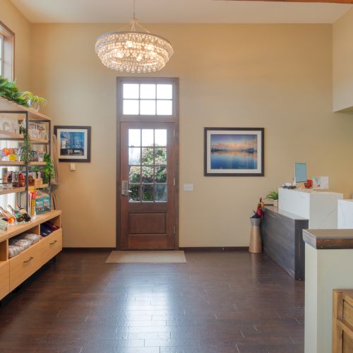 A bright, yellow kitchen with wooden cabinets, a small dining nook, and a door leading outside; cheerful, homey vibe.